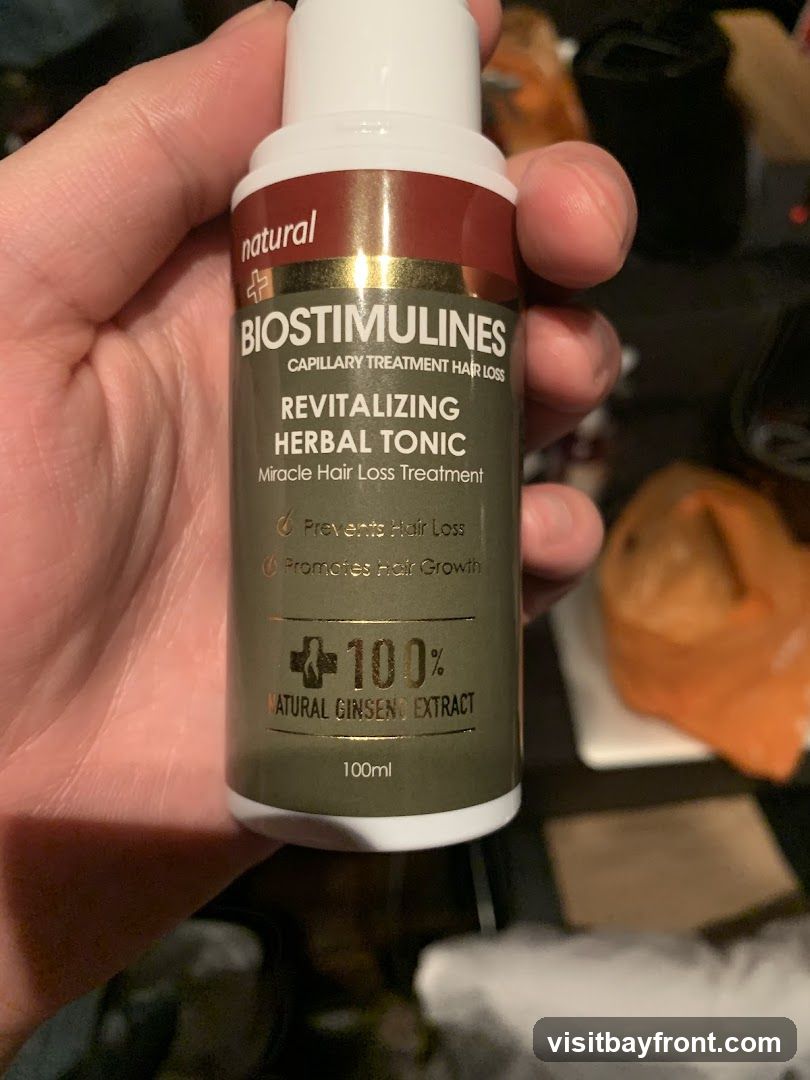 A bottle of Biostimulines Revitalizing Herbal Tonic, a capillary treatment for hair loss. The label states it is a miracle hair loss treatment that prevents hair loss and promotes hair growth. It contains 100% natural ginseng extract and is 100ml.