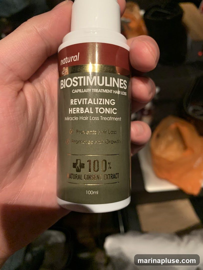 A bottle of Biostimulines Revitalizing Herbal Tonic, a capillary treatment for hair loss. The label states it is a miracle hair loss treatment that prevents hair loss and promotes hair growth. It contains 100% natural ginseng extract and is 100ml.