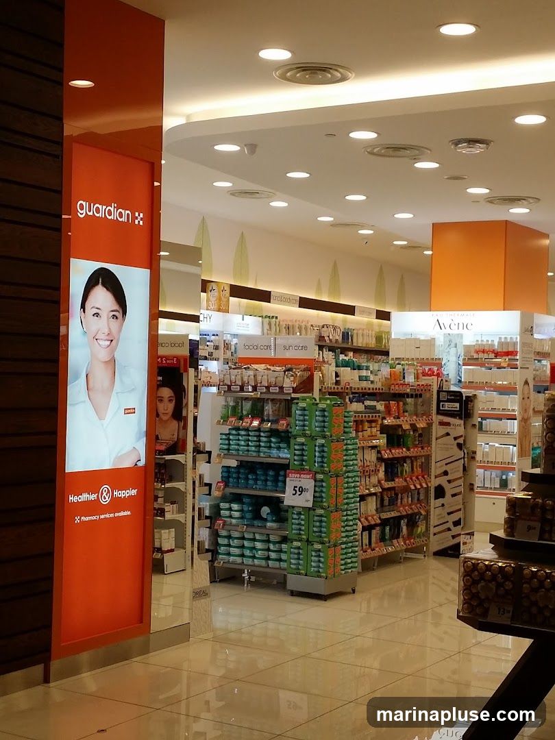 The interior of a Guardian pharmacy store. The entrance features a large orange panel with the Guardian logo and a smiling woman's face, along with the text "Healthier & Happier" and "Pharmacy services available." Inside, shelves are stocked with various health and beauty products, including skincare, haircare, and cosmetics. A display shows products with a "Save now!" tag and a price of 59.00.