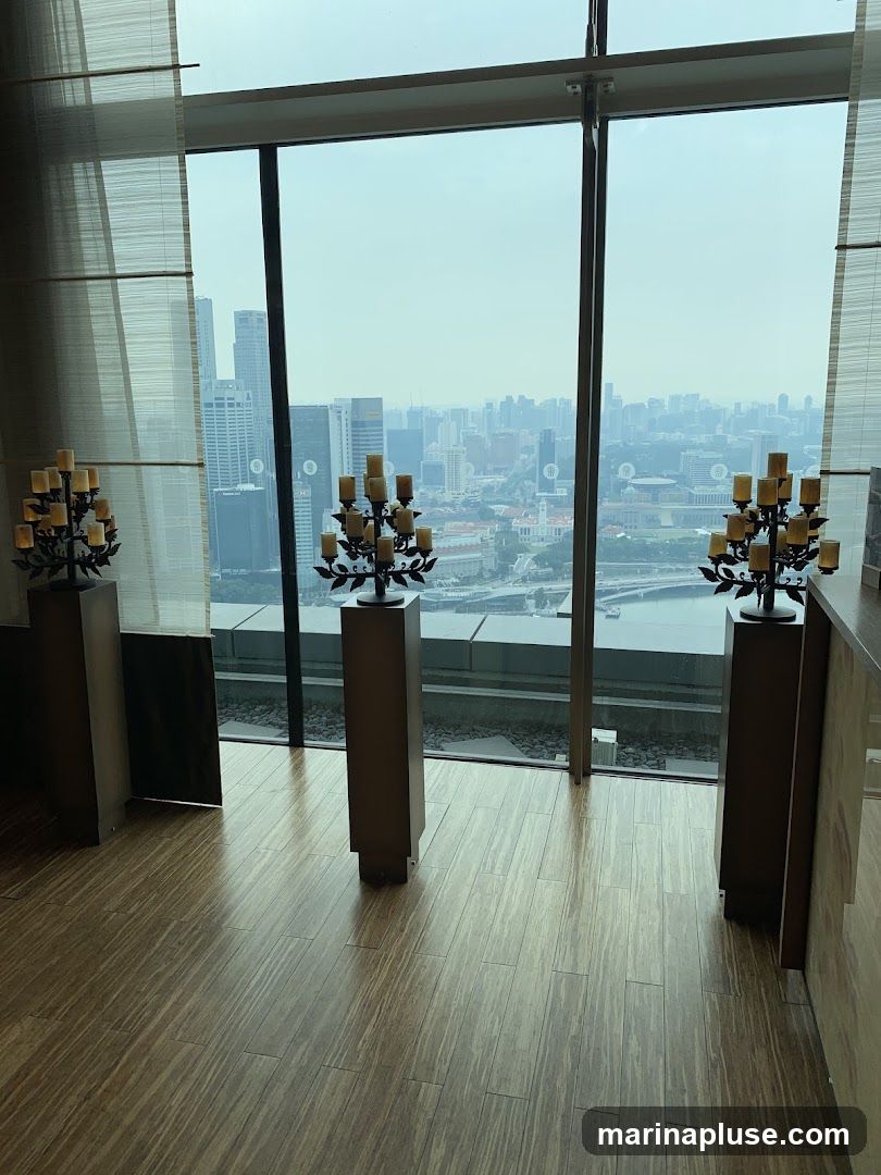 Three ornate candelabras stand on tall pedestals in front of a large window overlooking a sprawling cityscape. The floor is made of polished wooden planks. The candelabras have multiple candle holders, and the overall scene suggests an elegant interior space with a panoramic view.