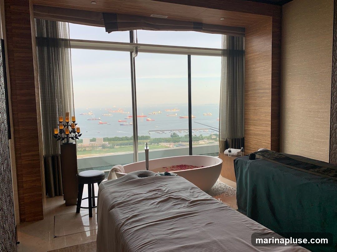 A luxurious spa room features two massage beds and a bathtub filled with rose petals, all overlooking a scenic ocean view with numerous ships. The room is decorated with elegant wooden paneling and ambient lighting from a candelabra.