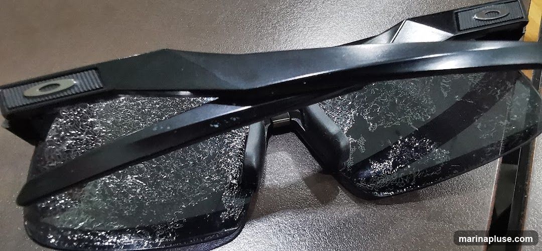A pair of black Oakley sunglasses with a textured pattern on the lenses. The Oakley logo is visible on the side of the frames.
