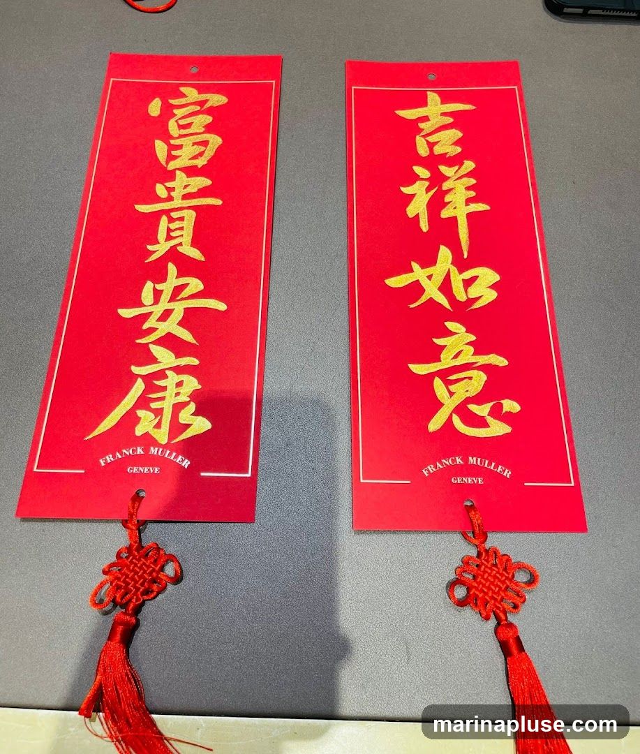 Two red and gold Chinese New Year couplets with tassels. The left couplet reads "富貴安康" (Fùguì ānkāng), meaning wealth, prosperity, peace, and health. The right couplet reads "吉祥如意" (Jíxiáng rúyì), meaning auspiciousness and good fortune. Both couplets feature the Franck Muller Geneve logo at the bottom.
