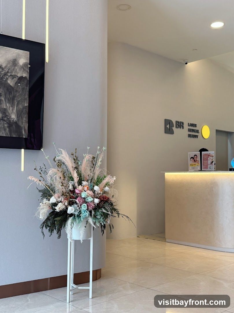A reception area with a counter, a large floral arrangement, and artwork on the wall. The counter has a light-up feature and a sign with images of people. The wall features a logo that reads "BR LASER MEDICAL BEAUTY" and a circular yellow element.