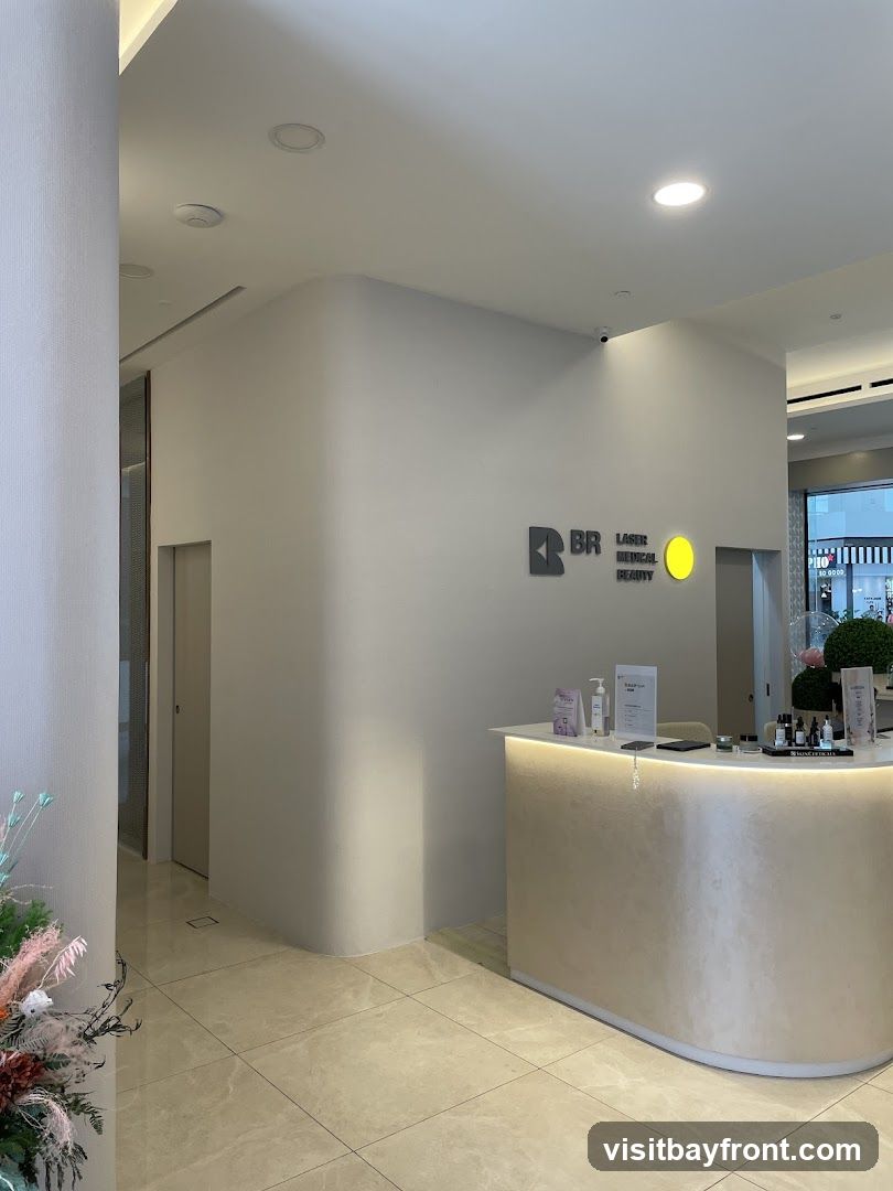 A reception desk with a logo that reads "BR LASER MEDICAL BEAUTY" is visible. There are bottles of products and a sign on the counter. The area is clean and modern with tiled flooring.