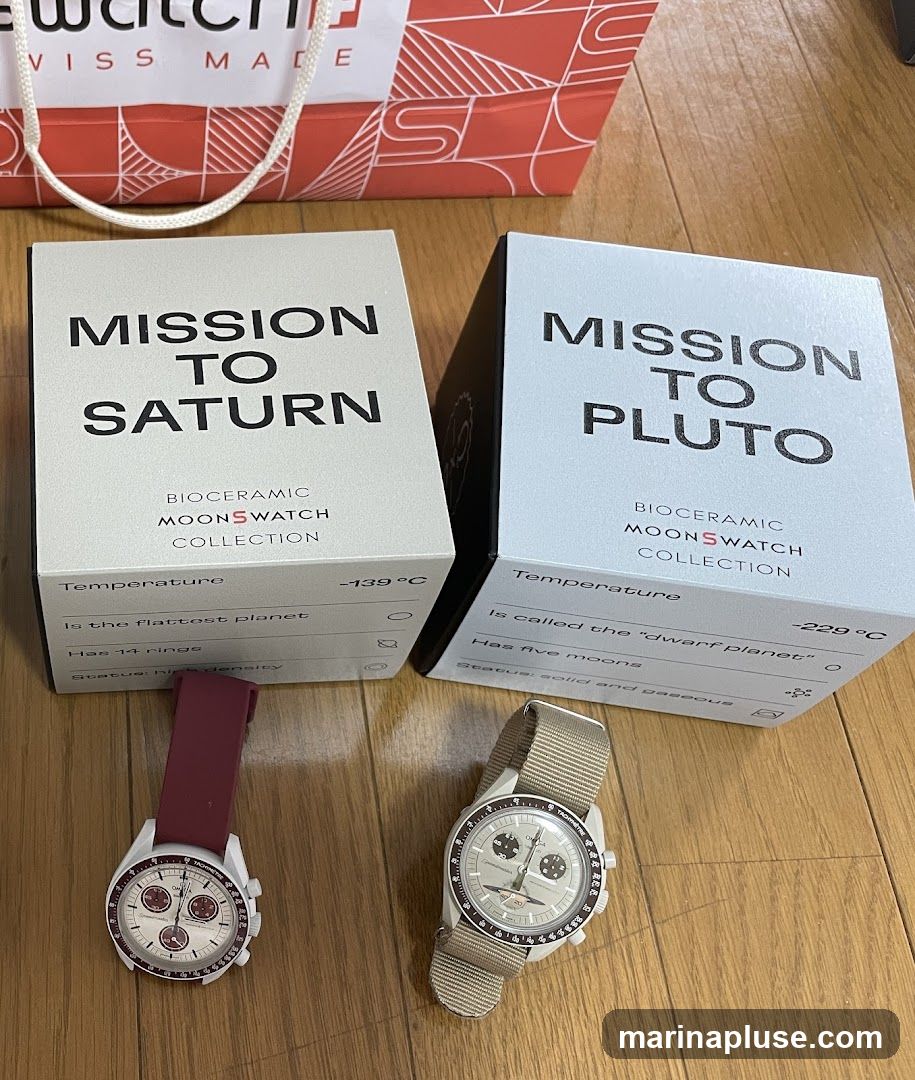 Two Swatch MoonSwatch watches, one labeled "Mission to Saturn" and the other "Mission to Pluto," are displayed on a wooden floor. Both watches are in their original boxes, which feature details about the celestial bodies they represent. A Swatch shopping bag is visible in the background.