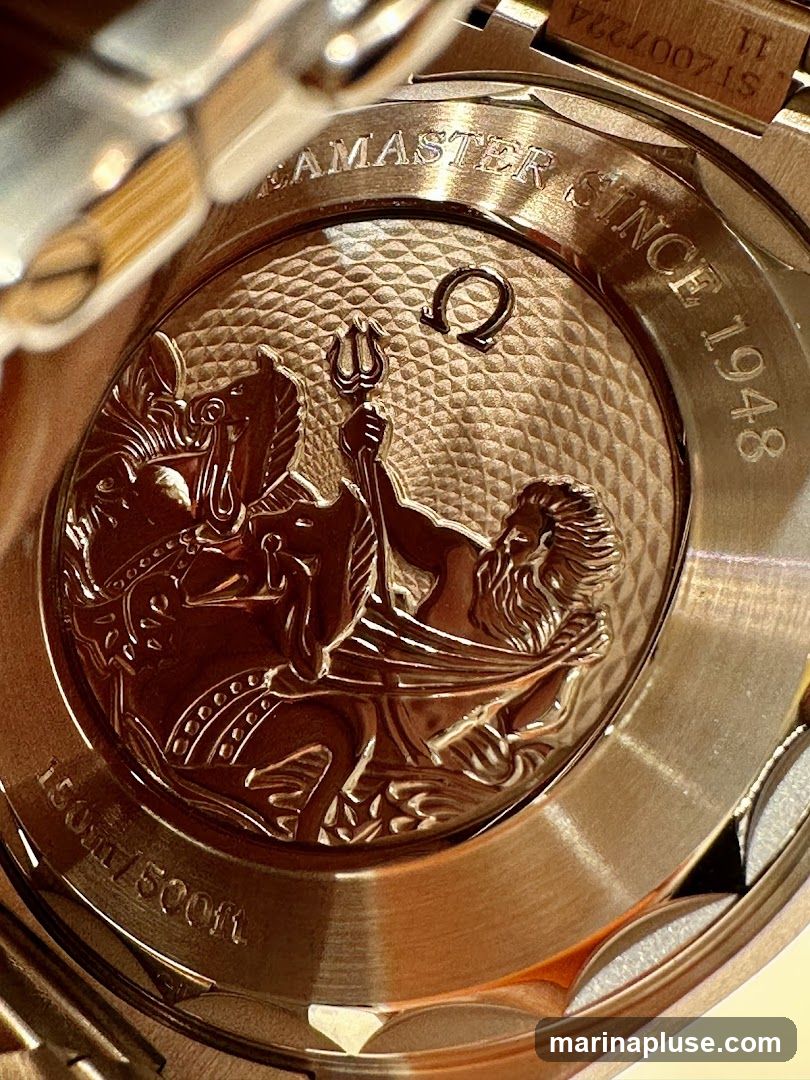 The image shows the engraved case back of a luxury watch. The engraving features a detailed depiction of Poseidon, the Greek god of the sea, riding a chariot pulled by seahorses. Around the central image, text reads "SEAMASTER SINCE 1948" and "150m / 500ft". A small Omega symbol is also visible. The metal appears to be gold or rose gold, with a brushed finish on the outer ring and a textured background within the engraved area.