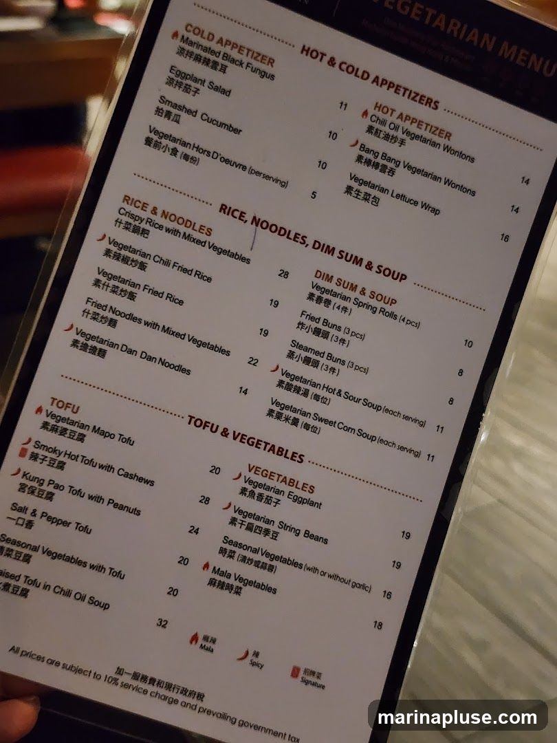 A vegetarian menu with sections for Cold Appetizers, Hot & Cold Appetizers, Rice & Noodles, Dim Sum & Soup, Tofu, and Vegetables. Prices are listed in a currency symbol that is not visible. All prices are subject to a 10% service charge and prevailing government tax.