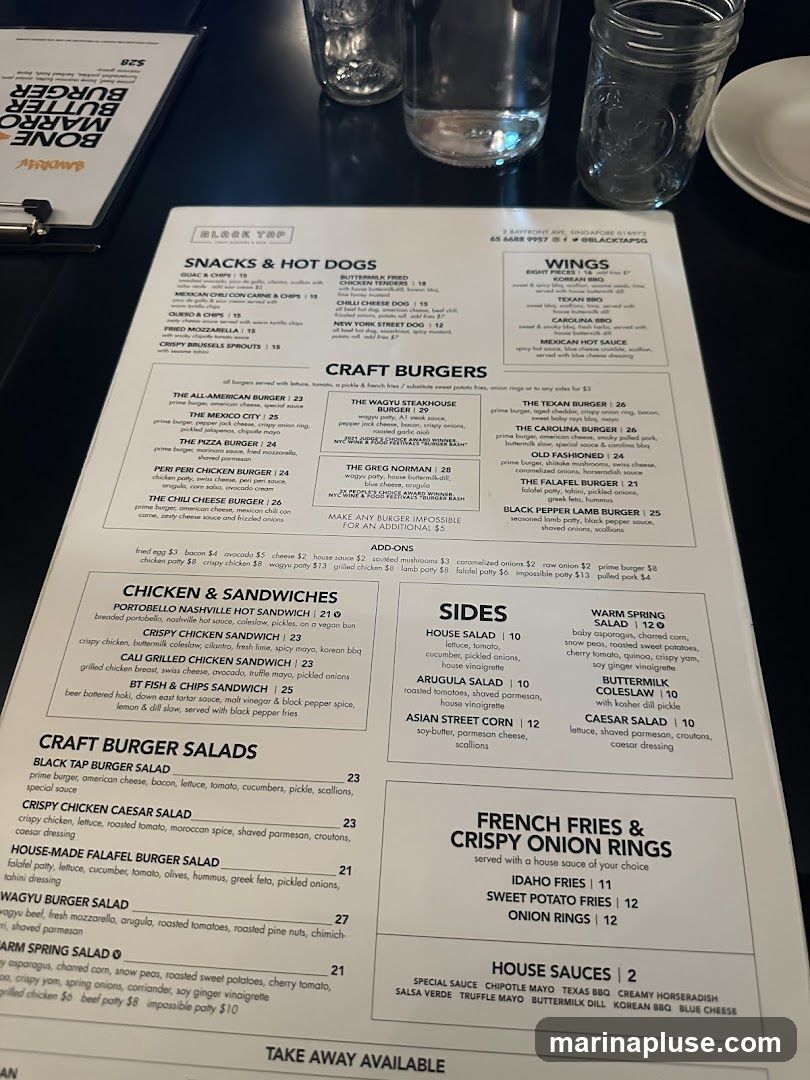 A menu from Black Tap featuring snacks, hot dogs, wings, craft burgers, chicken & sandwiches, craft burger salads, sides, french fries & crispy onion rings, and house sauces.