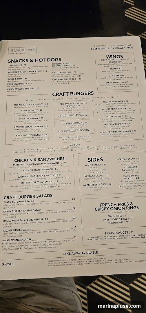 A menu from Black Tap featuring snacks, hot dogs, craft burgers, chicken sandwiches, salads, sides, and french fries/onion rings.