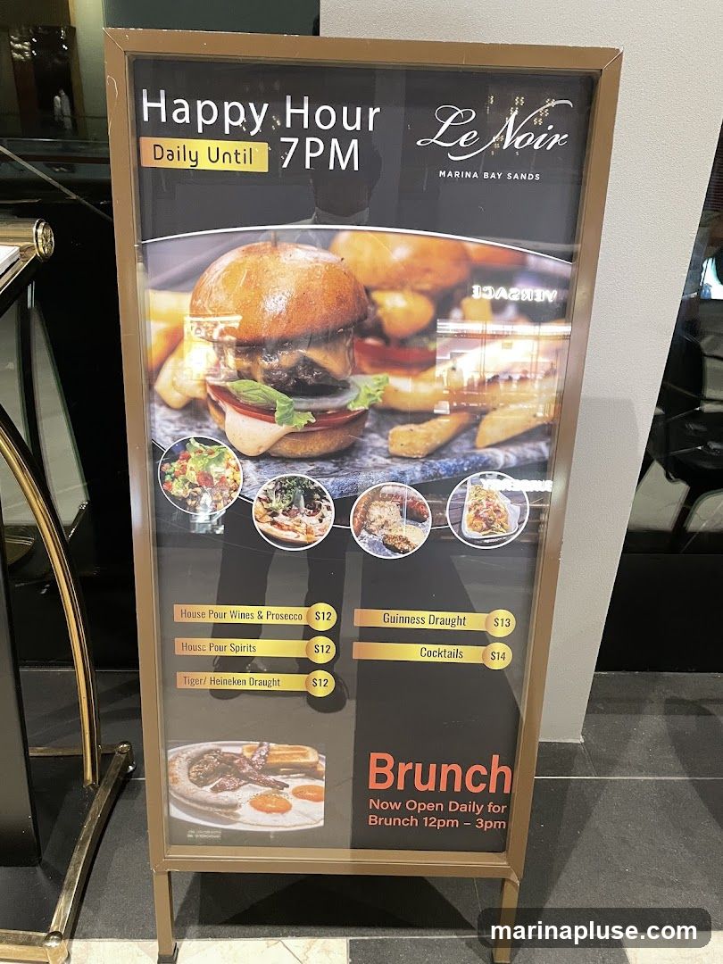 A-frame sign advertising Happy Hour daily until 7 PM and Brunch. Features images of a burger, small plates, and a full breakfast.