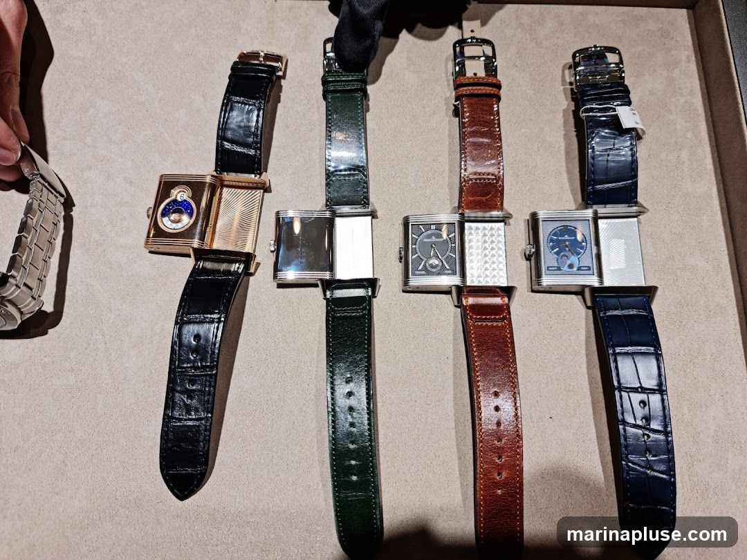 A collection of five luxury watches with leather straps and metal bracelets are displayed on a textured surface. The watches feature rectangular cases with various dial designs, including moon phases and intricate patterns. One watch is gold-toned with a black leather strap, while others are silver-toned with green, brown, and blue leather straps. A metal bracelet watch is partially visible on the left.