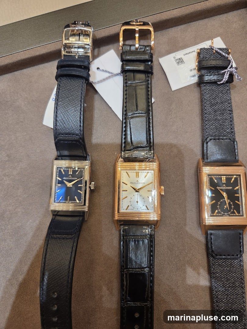 Three rectangular watches with leather and fabric straps are displayed side-by-side. The watches have gold-toned cases and different dial colors: blue, white, and black. Each watch features a brand name and model visible on the dial.