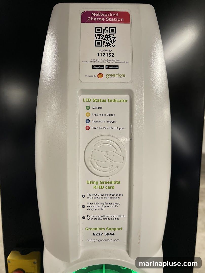 A white electric vehicle charging station with instructions on how to use it. It displays a QR code, station ID, LED status indicator, and support contact information.