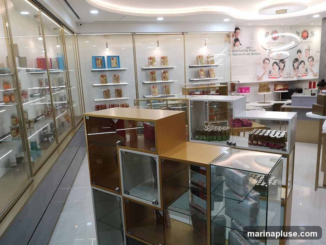 The interior of a store selling wellness products. Display cases line the walls and are arranged in the center of the room, showcasing various jars, boxes, and bottles of products. A large promotional poster with images of families and text about wellness is visible on the back wall.
