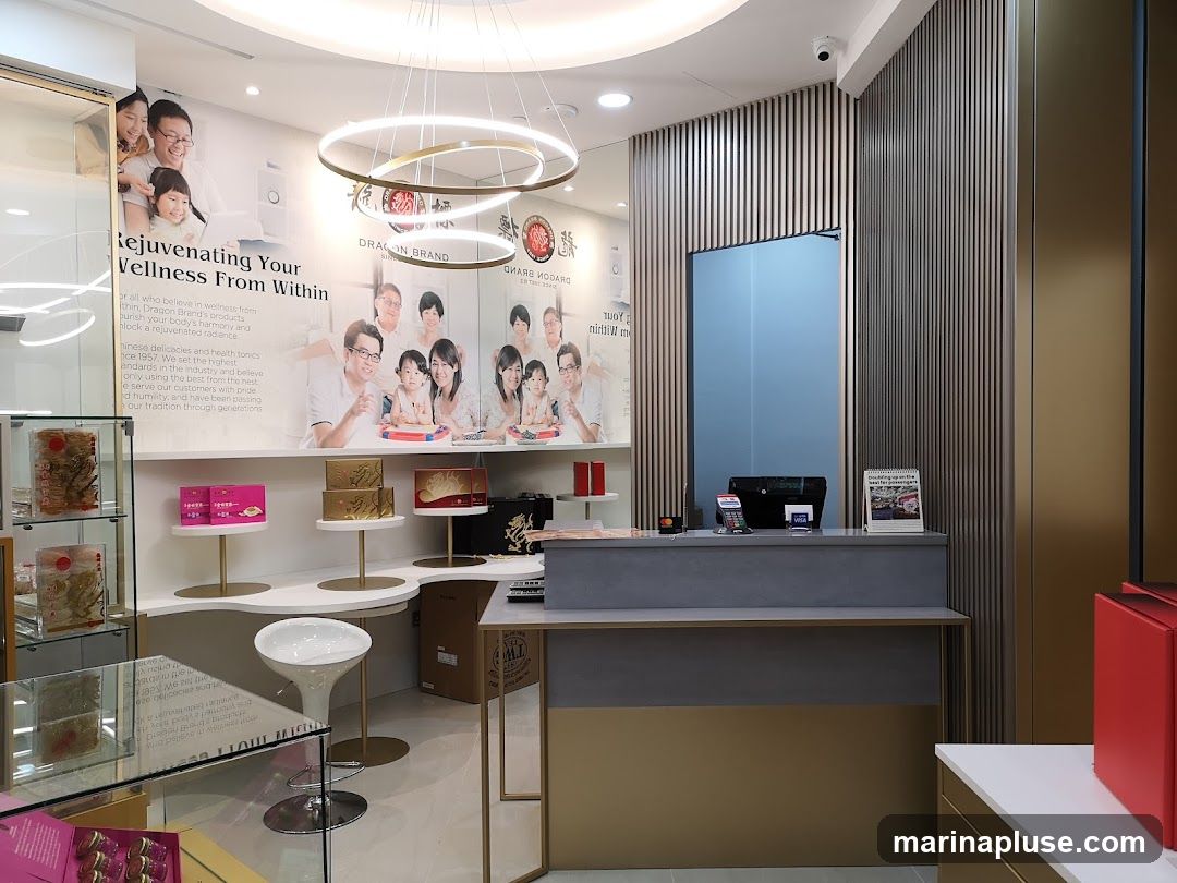 The interior of a store features a counter with a cash register and a calendar. Behind the counter, a wall is decorated with a large mural depicting families and text about wellness products. To the left, glass display cases showcase products, and shelves hold boxes of merchandise. A white stool is placed near the counter.