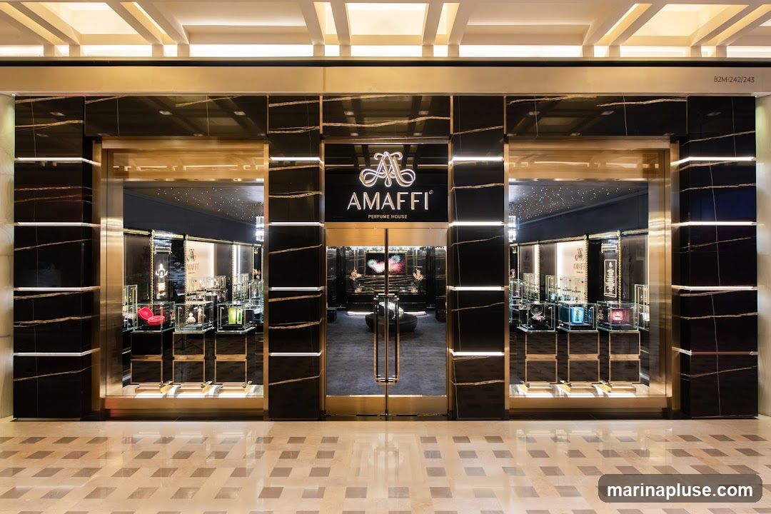The exterior of a luxury perfume store with a black marble facade and gold accents. The store's name, "AMaffi PERFUME HOUSE," is prominently displayed above the entrance. The interior is visible through large glass doors and windows, showcasing display cases filled with perfume bottles and other luxury items.