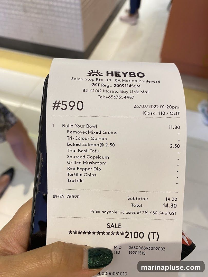 A receipt from HEYBO, a salad stop, detailing a 'Build Your Bowl' order with various ingredients and prices. The total amount is $14.30.
