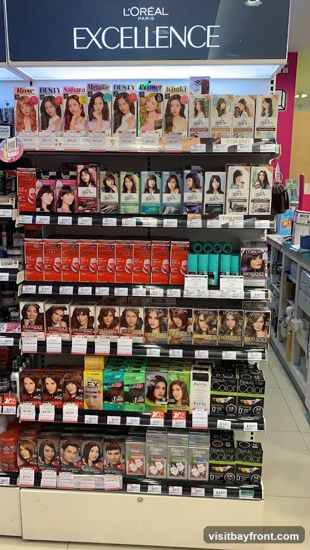 A retail display featuring various shades of L'Oréal Excellence hair color products. The top shelf showcases different shades like Rose, Dusty, Sahara, Metallic, Primer, and Khaki, with prices listed below. The subsequent shelves display more hair color boxes from brands like L'Oréal, Revlon, and Bigen, along with other hair care products. Prices are visible for many items.