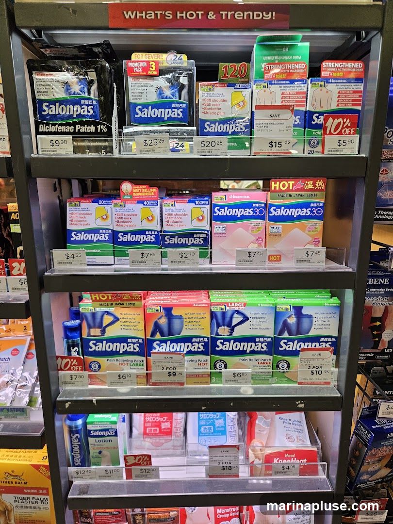 A display shelf filled with various Salonpas brand pain relief patches and lotions. Products include Diclofenac Patch 1%, Salonpas 30, and Salonpas Lotion. Prices and promotional offers are visible on some items.