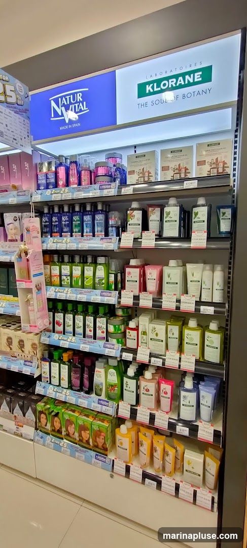 A retail display featuring various skincare and haircare products from brands like Natur Vital and Klorane. The shelves are stocked with bottles, jars, and boxes of lotions, shampoos, conditioners, and hair growth kits. Promotional signs indicating discounts like "2 FOR $25" and "SAVE" are visible on some shelves.